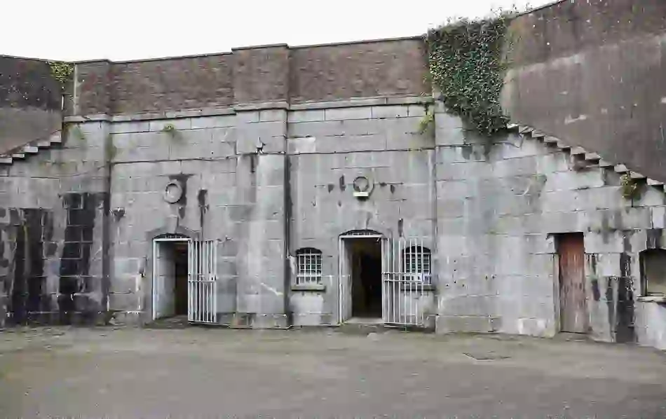Grey stone prison building with barred doors at Spike Island, County Cork.