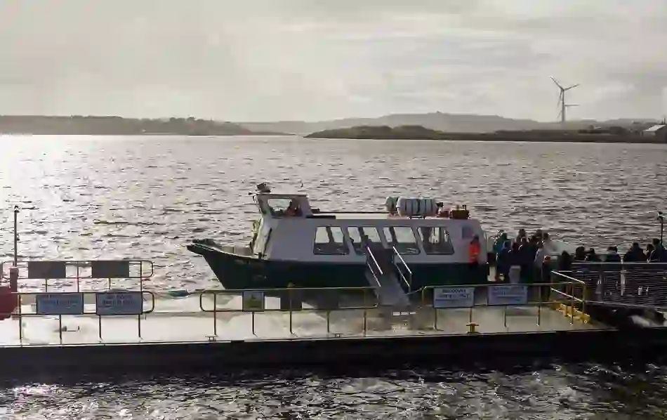 Passenger ferry docked at a pier with people boarding for the trip to Spike Island.