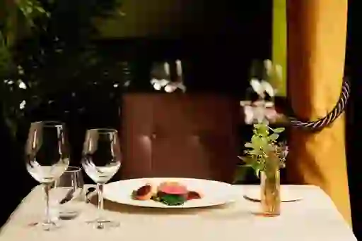 Elegant fine dining table set with a plated gourmet dish, wine glasses and soft lighting in a Michelin-star restaurant in Ireland.