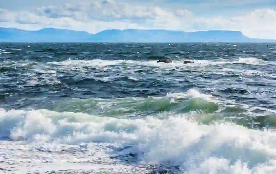 Waves crashing on the shore at Muckross in County Donegal, with mountains in the distance.