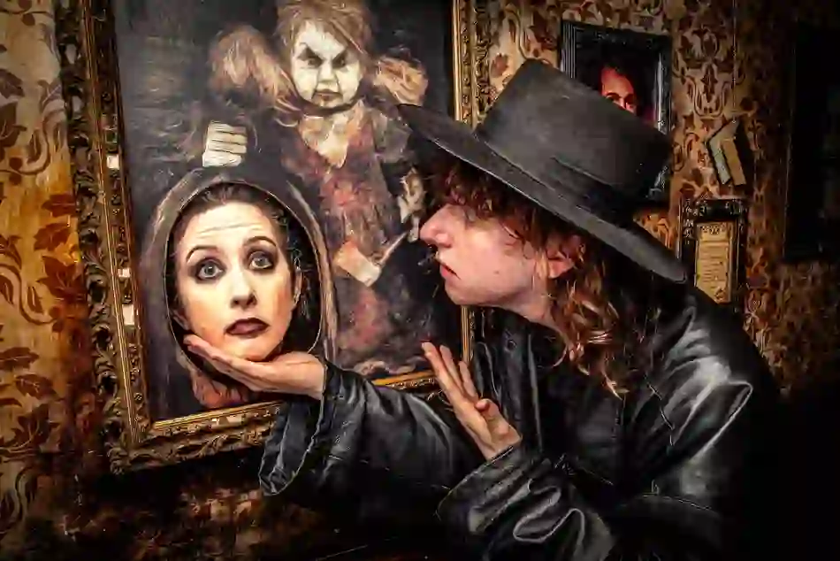 Actor in gothic costume poses with a framed illusion of a severed head on the Ghostbus Tour in Dublin city.