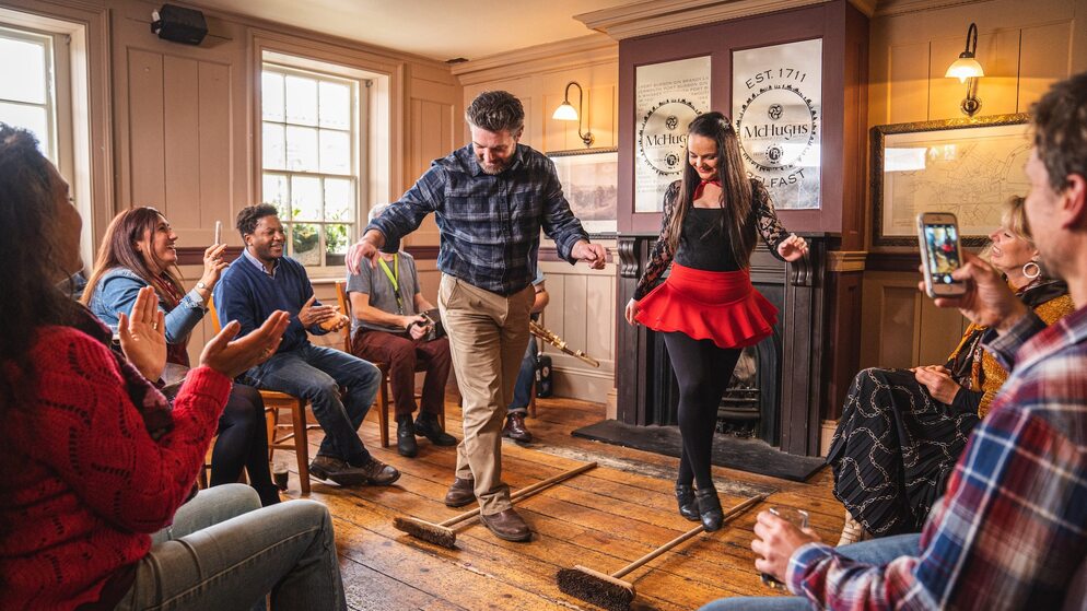 Traditional Irish dancing performance in a Belfast pub with people clapping.