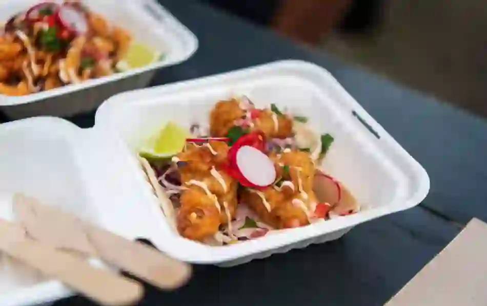 Close-up of fish tacos with lime and garnish served in a takeaway box in Derry~Londonderry.