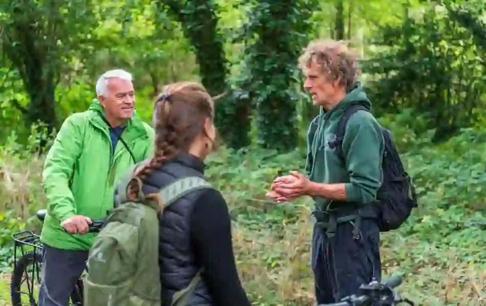 Guide speaking to cyclists during a forest stop on a Derry~Londonderry cycle tour.