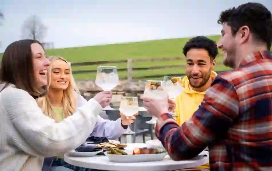 Friends enjoying Shortcross gin outdoors at Rademon Estate Distillery, County Down.