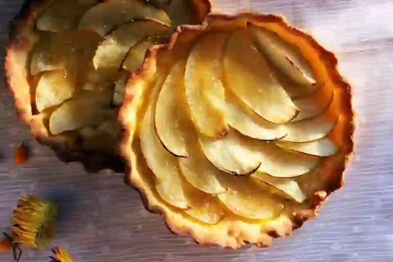 Golden apple tartlets with thinly sliced apples baked in crisp pastry shells.
