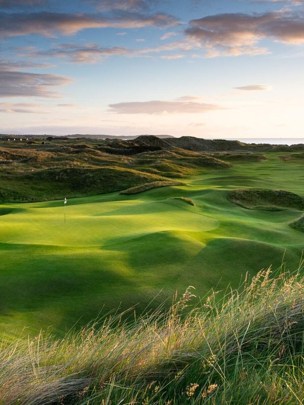 Sunset over rolling fairways at a links golf course in Ireland’s Ancient East with scenic dunes.
