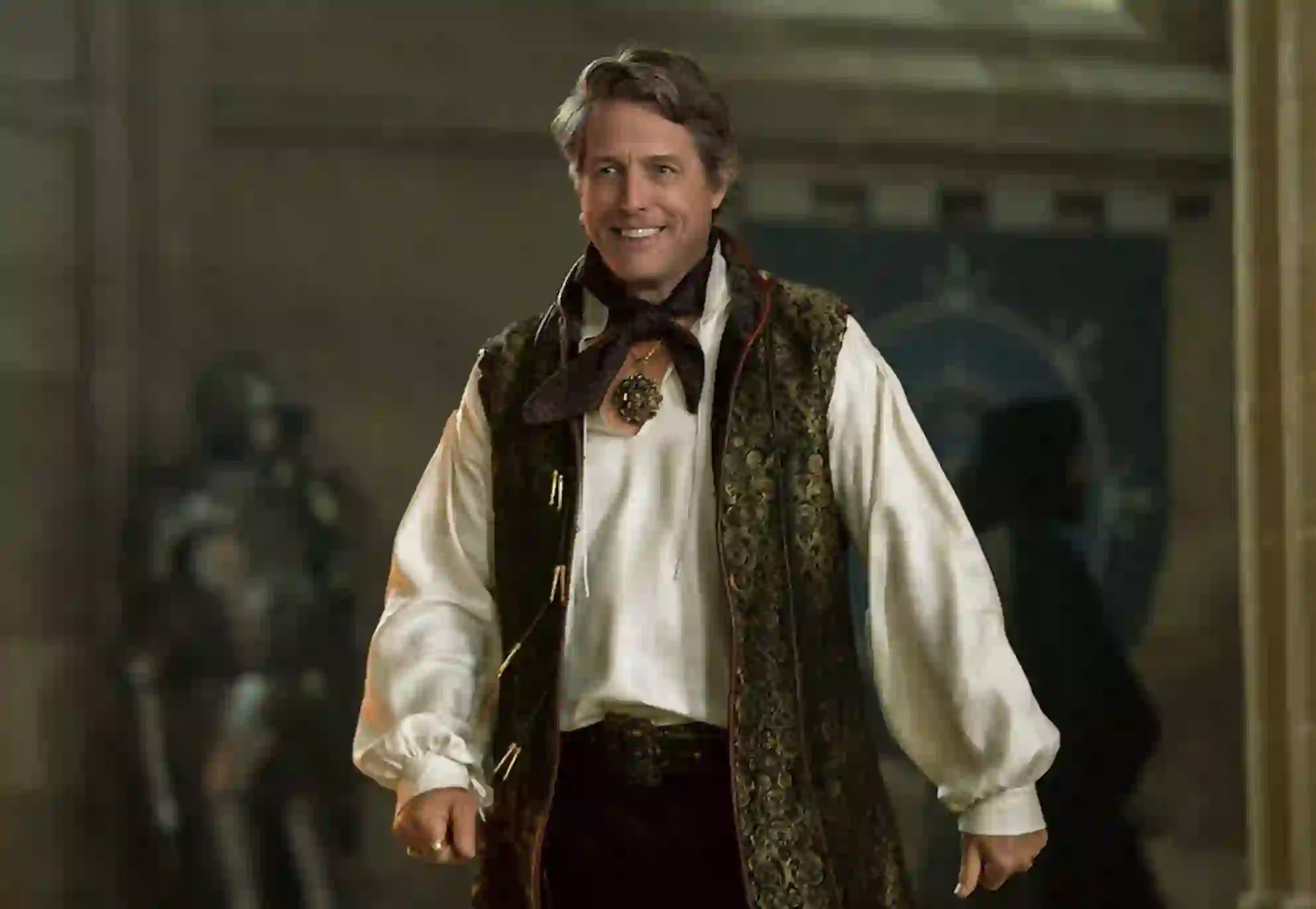 Hugh Grant smiling in ornate costume as Forge Fitzwilliam in Dungeons &amp; Dragons: Honor Among Thieves.