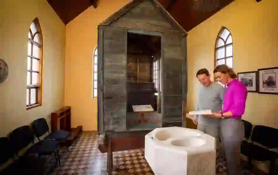 Couple reading beside The Little Ark, a mobile wooden church box used during penal times in County Clare.