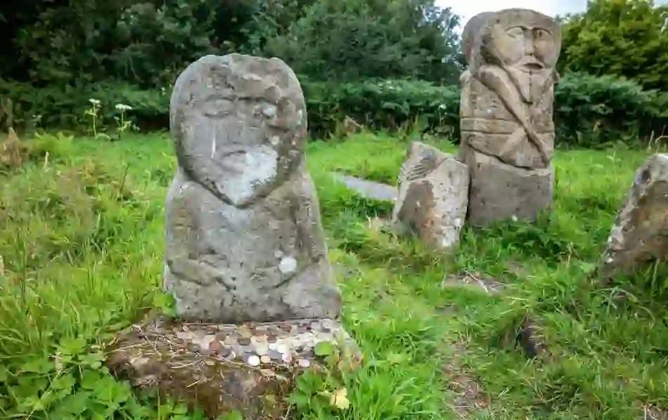 Celtic carved stone figures with offerings at Caldragh graveyard on Boa Island in County Fermanagh.