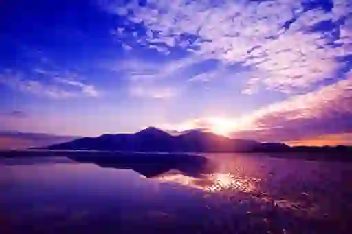 Winter sunset over Murlough Beach, County Down, with mountains reflected in calm tidal waters.