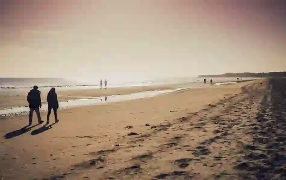 Walkers enjoy Sandymount Strand in Dublin, a setting evoked in the writings of Irish novelist Colm Tóibín.