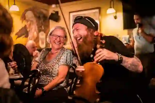 Traditional musician entertaining visitors during a lively Irish music session in McHugh's pub, Belfast.