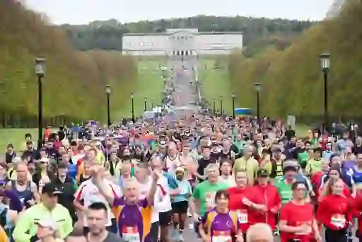 Thousands of runners in colourful athletic gear fill Prince of Wales Avenue at Stormont Estate during the Belfast City Marathon.