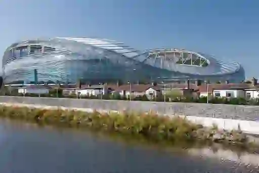 Aviva Stadium’s glass exterior reflecting blue skies beside the River Dodder in Dublin’s Ballsbridge neighbourhood.