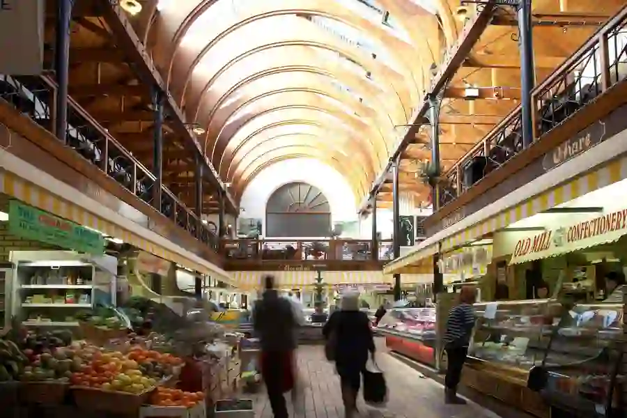Shoppers browse fresh produce and artisan stalls beneath the vaulted wooden ceiling of the English Market in Cork.