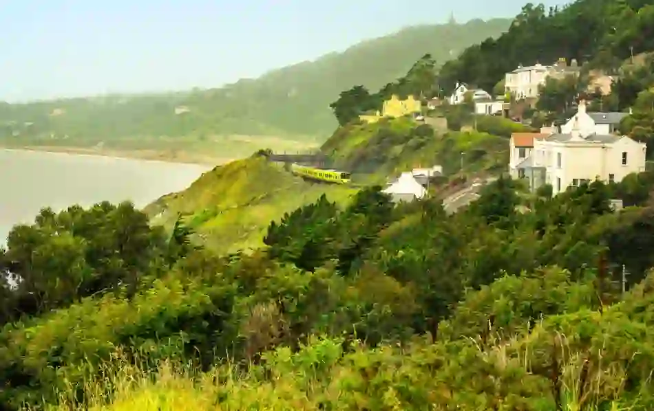 The coastal DART train winds past green cliffs and villas overlooking the sea near Killiney.