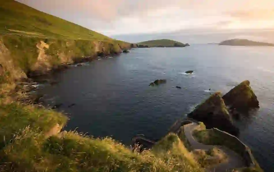 The iconic zigzag path at Dunquin Harbour, Kerry, descends dramatically to the sea with views of rugged cliffs and rocky islands.