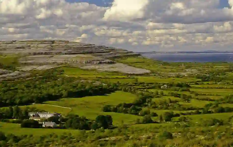 The unique rocky limestone landscape of the Burren, County Clare, stretches into the distance, dotted with green fields.