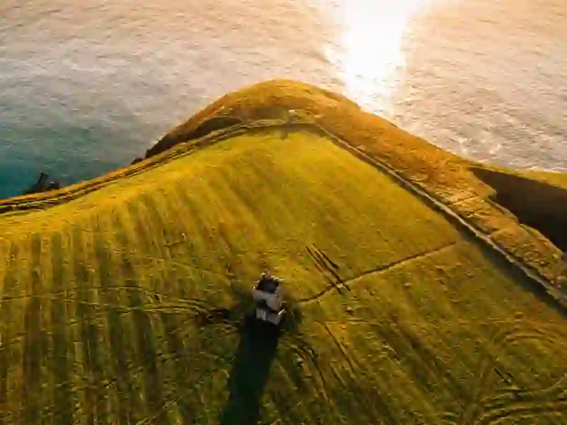 Sunset over a grassy headland and small tower on St Declan’s Way overlooking the Atlantic.