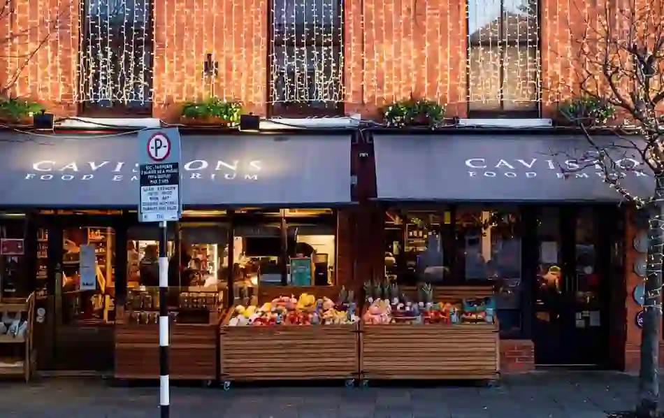 Caviston's Food Emporium shopfront in County Dublin lit with fairy lights, fresh produce displayed in wooden crates outside.