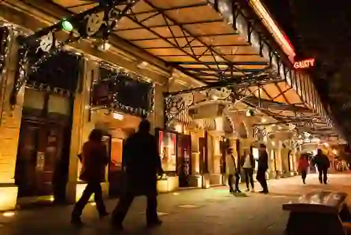 People outside the Gaiety Theatre in Dublin lit up with festive lights at night.