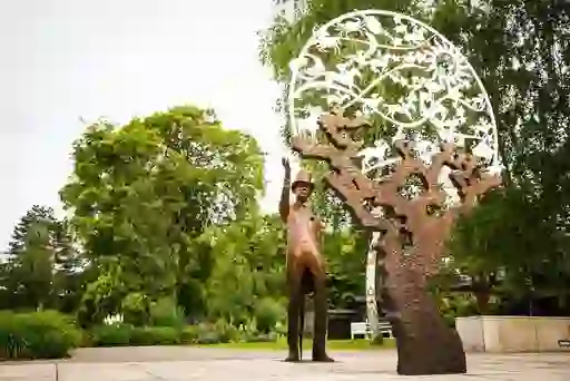 Bronze statue of a man in a top hat beside an artistic sculpture at the Irish National Stud in County Kildare.