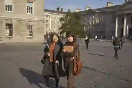 Students walk through cobbled Trinity College Dublin quad.