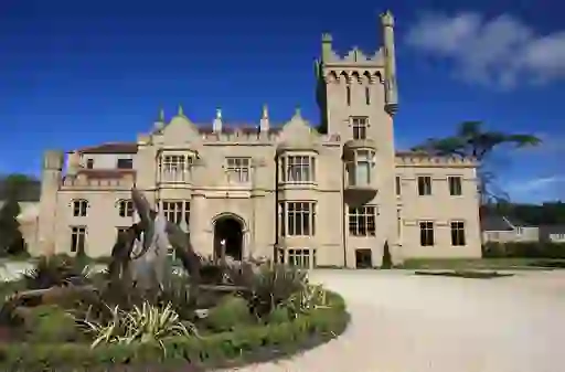 Neo-Gothic Lough Eske Castle with bay windows, turret and dolphin fountain in County Donegal.