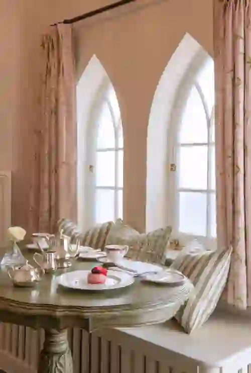 Elegant afternoon tea for two at a window nook in the Cashel Palace Hotel, County Tipperary, with vintage decor and fine china.