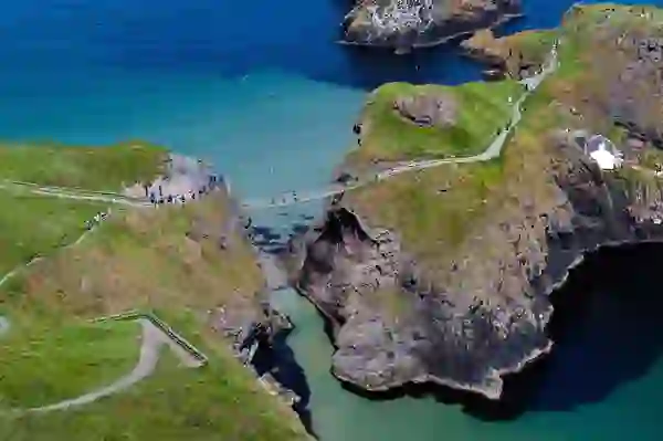 Visitors crossing Carrick-a-Rede Rope Bridge above the sea on the Causeway Coastal Route, County Antrim.