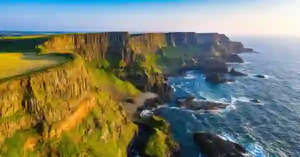 Basalt cliffs on the Causeway Coast in County Antrim above the Atlantic Ocean at golden hour.