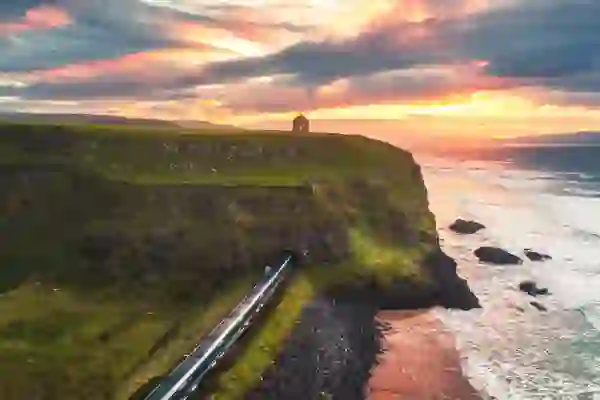 Train emerging beneath Mussenden Temple beside Downhill Strand at sunset, County Londonderry.
