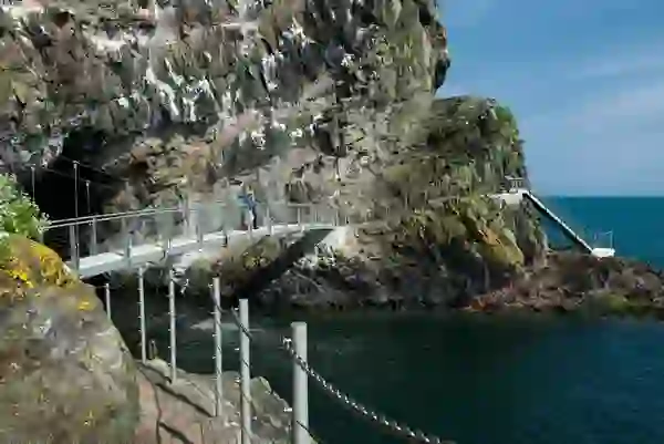 Visitors walking along The Gobbins cliff path above the sea, County Antrim.