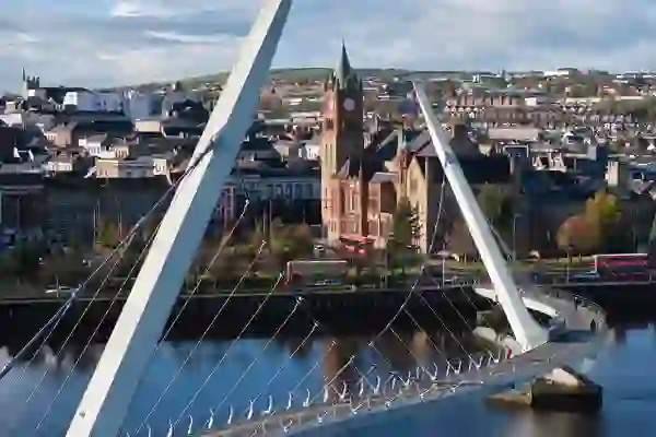 Derry~Londonderry skyline framed by the Peace Bridge crossing the River Foyle.