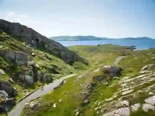 Narrow coastal road winding through rocky hills on the Beara Peninsula with views across the Atlantic.
