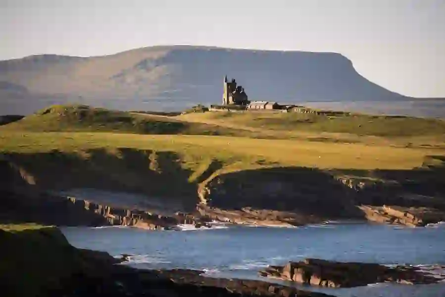 Classiebawn Castle on a grassy headland overlooking the sea with Ben Bulben in the background, County Sligo.