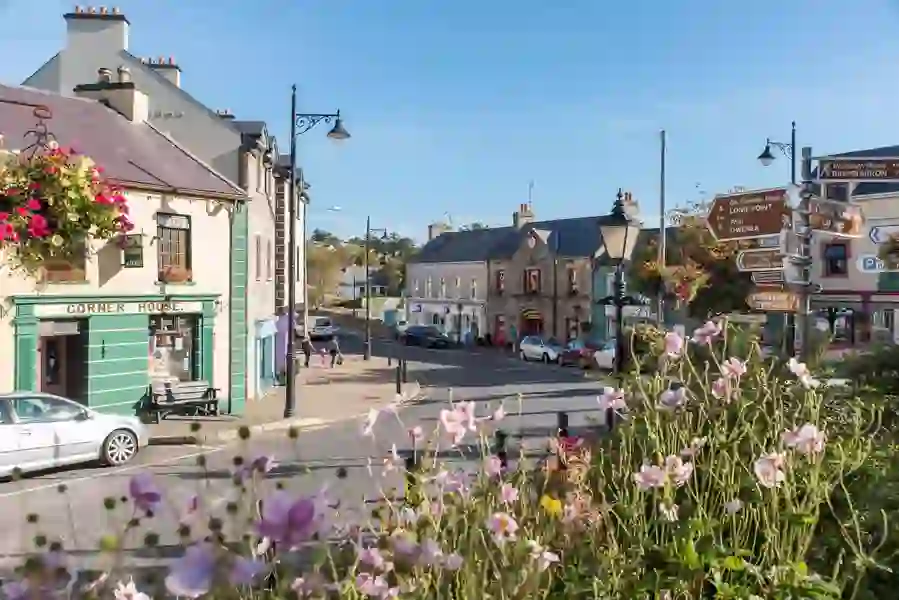 Charming street scene in Ardara, County Donegal, with hanging flower baskets and traditional Irish shopfronts.
