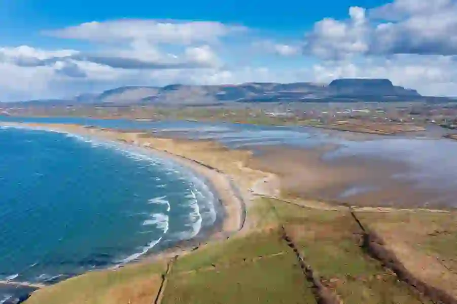 Aerial shot of Streedagh Beach curving along the Atlantic with Ben Bulben mountain in the distance, County Sligo