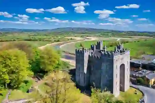 Bunratty Castle beside the River Ratty in County Clare, surrounded by green countryside.