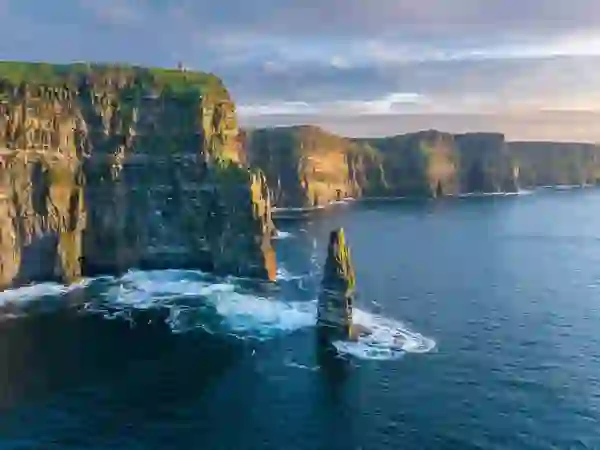Sea stack and towering Cliffs of Moher rising above the Atlantic Ocean in County Clare.