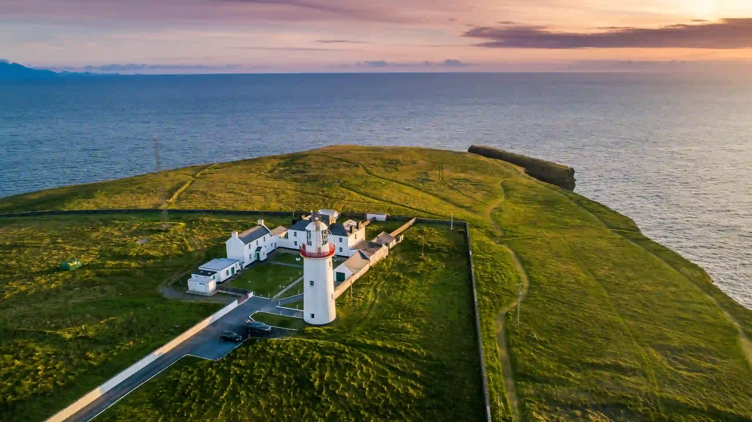Overhead view of Loop Head Lighthouse on a rugged and green peninsula in County Clare.