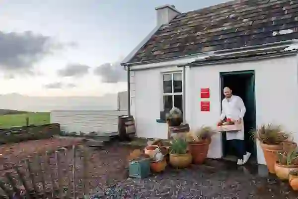 Chef carrying fresh local produce outside Homestead Cottage in County Clare.