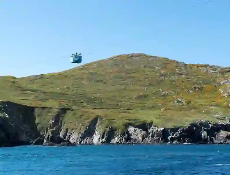 Dursey Island cable car crossing over coastal cliffs towards grassy hilltop in County Cork.