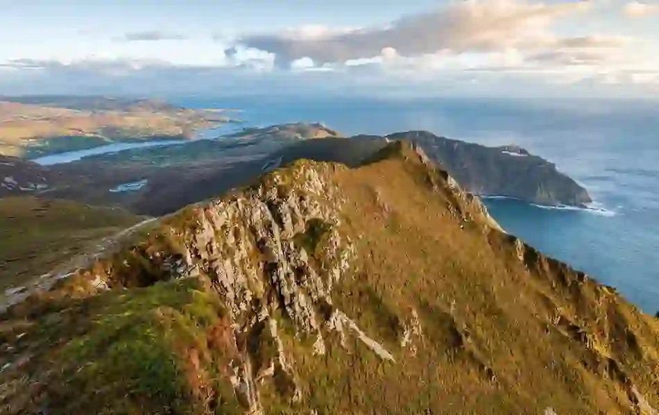 Dramatic aerial view of Slieve League Cliffs in County Donegal, with the Atlantic Ocean stretching beyond steep, rugged slopes.