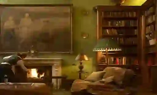 Elegant library with a crackling fire, large portrait and leather armchairs at Castle Leslie Estate, County Monaghan.
