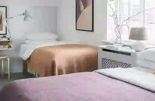 Twin room at The Stop B&B in Galway city with minimalist decor, framed art and soft-toned woven blankets.