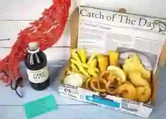 Seafood box from Killybegs Seafood Shack, County Donegal, with fish, chips, onion rings, and tartar sauce.