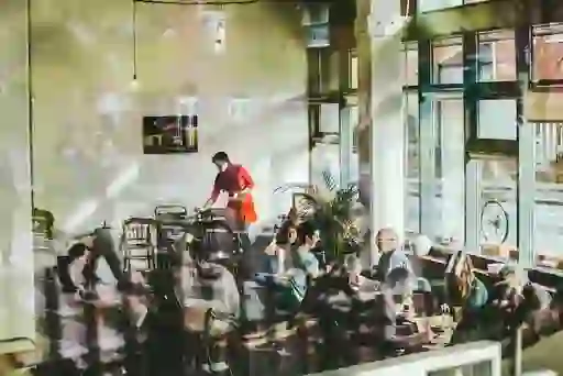 People socialising inside a busy Dublin café – The Fumbally – with large windows and warm light.