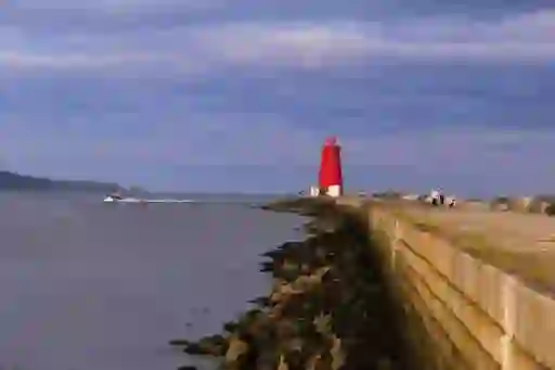 Bright red Poolbeg Lighthouse at the end of the Great South Wall in Dublin Bay.